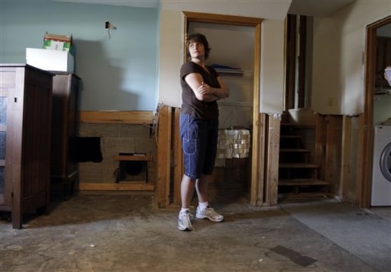 Kellie DeVault looks over a flood-damaged basement in Greenwood, Ind., on Aug. 18. DeVault and her family are moving out of the damaged home and are seeking a buyout for the damaged property.